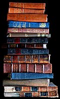 [picture: Stack of old books, dark background]