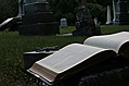 [Picture: Open Bible and cross in graveyard]