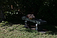 [Picture: Stone bench with books and cross]