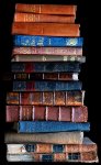 [Picture: Stack of old books, dark background]